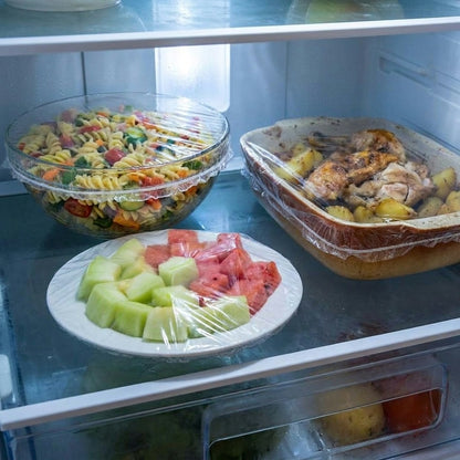 Étagère de frigo avec plats couverts par des charlottes transparentes